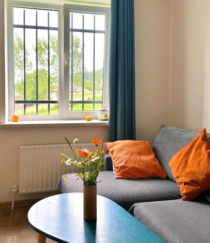 a living room with a couch and a table with flowers at Cozy Dez Guest House with Dreamy Mountain Views in Margahovit