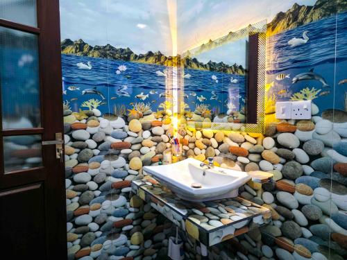 a bathroom with a painting of a rocks and a sink at Dishan Green Retreat in Ambalangoda