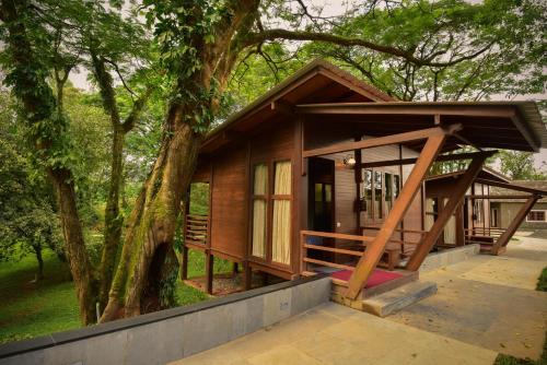 a small cabin in a forest with a tree at Sirukundra Garden Bungalow in Vālpārai