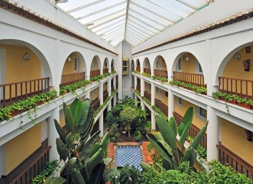 an indoor courtyard with a pool in a building at SOL by Meliá Los Fenicios in La Herradura