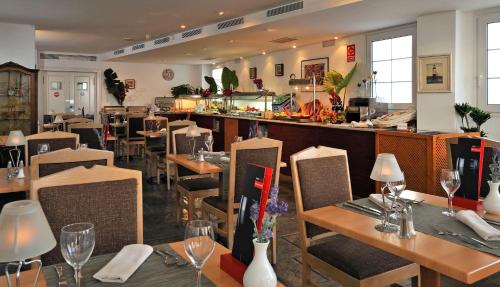 a restaurant with tables and chairs and a bar at SOL by Meliá Los Fenicios in La Herradura
