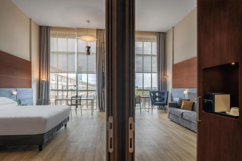 a hotel room with a bed and a living room at DoubleTree by Hilton Turin Lingotto in Turin