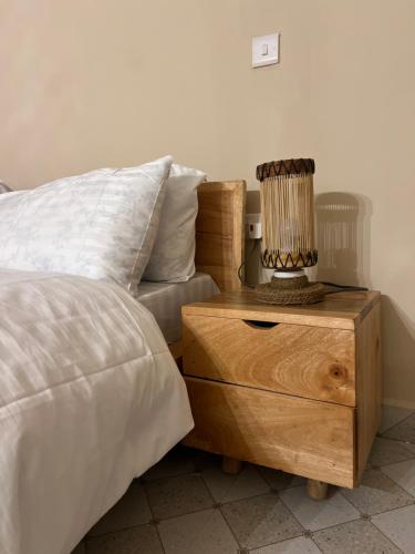 a bed and a nightstand with a lamp on top of it at Garden Breeze in Bwejuu