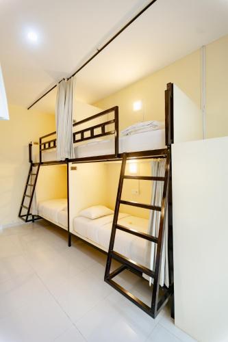 two bunk beds in a room with a ladder at V Canggu Dormitory in Canggu