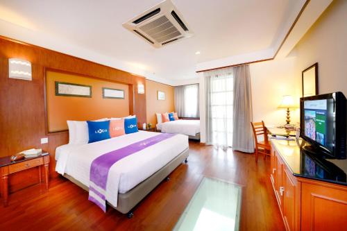 een hotelkamer met een groot bed en een televisie bij Lexis Port Dickson in Port Dickson