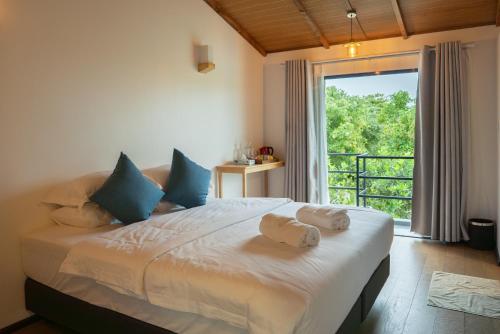 a bedroom with a large bed with towels on it at Arena Blanca in Rasdhoo
