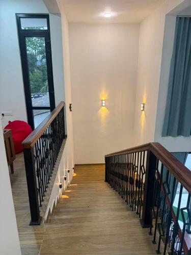 eine Treppe in einem Haus mit zwei Lichtern an der Wand in der Unterkunft 32AW hotel in Matale