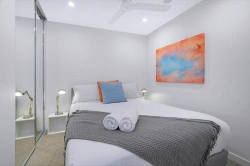 a bedroom with a bed with two towels on it at Bright CBD 2 bedroom resort-style escape in Brisbane