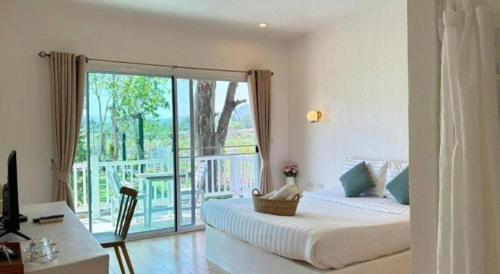 a bedroom with a bed and a balcony at Charisma Resort in Suan Phung