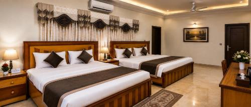 a hotel room with two beds in a room at Galaxy Inn Guest House in Karachi