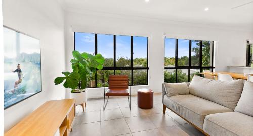 a living room with a couch and some windows at Palm Cove Retreat I heated pool I Family home in Palm Cove
