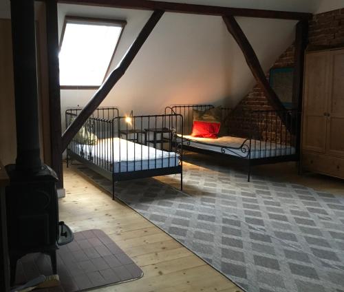 a attic room with two beds and a window at Ku Wiśle 