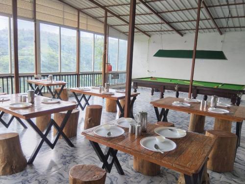 a room with wooden tables and a pool table at Kalasita in Mahabaleshwar