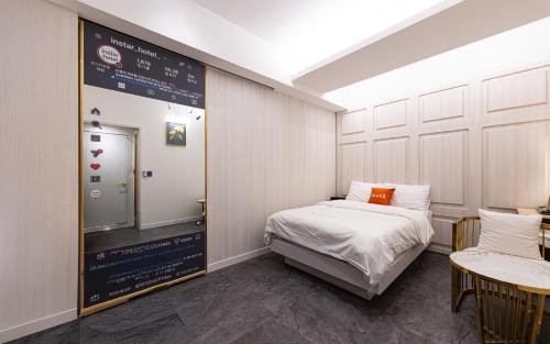 a room with a bed and a sign on the wall at Instar Hotel in Suwon