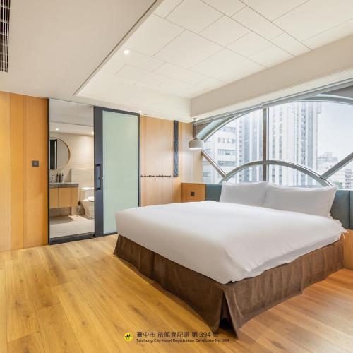 a bedroom with a large bed and a large window at CHECK inn Taichung Wenxin Zhongqing in Taichung
