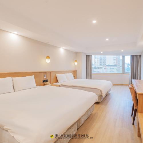 a hotel room with two beds and a window at Hamilton Hotel in Taichung