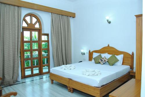 1 dormitorio con 1 cama blanca grande y ventana en Hotel isabel Palace, en Khajurāho