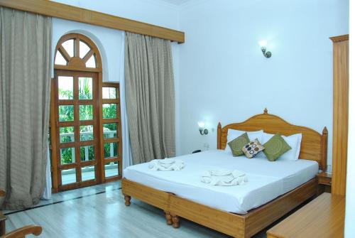 a bedroom with a large white bed with a window at Hotel isabel Palace in Khajurāho