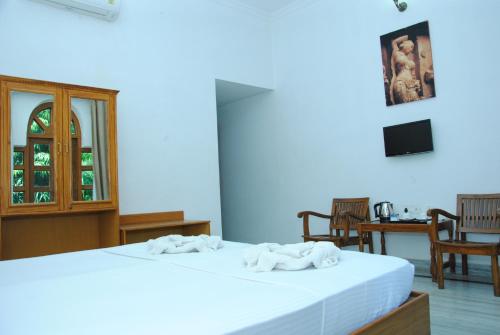 a bedroom with two white towels on a bed at Hotel isabel Palace in Khajurāho