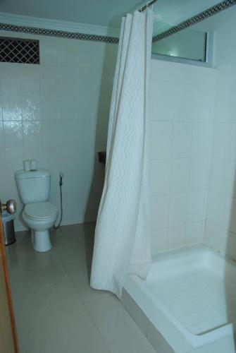 a bathroom with a toilet and a shower with a shower curtain at Hotel isabel Palace in Khajurāho