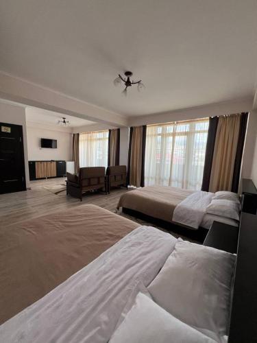 a large bedroom with two beds and a couch at Asman Hotel in Bosteri