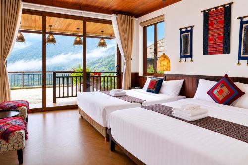 two beds in a room with a balcony at Larosa Homestay Sapa in Sa Pả