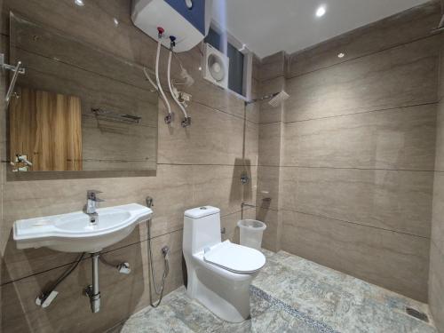 a bathroom with a toilet and a sink at Hotel Satyaki Orchid in Katra