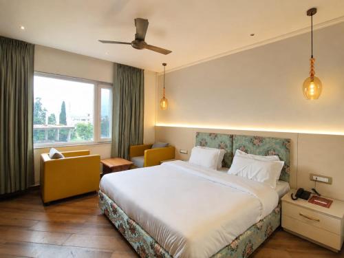 a hotel room with a bed and a window at Hotel Satyaki Orchid in Katra