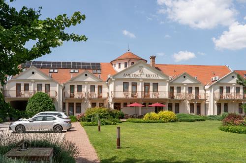 a large house with a car parked in front of it at Ametiszt Hotel Harkány in Harkány