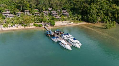 a group of boats docked in the water next to a resort at TreeHouse Villas Koh Yao - Adults Only in Ko Yao Noi