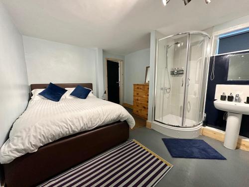 a bedroom with a bed and a shower and a sink at Albert Road Flat 4 in Colne