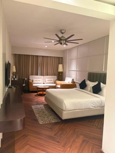 a bedroom with a large bed and a living room at Besstin Hotel in Hisār