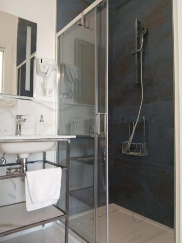a bathroom with a glass shower and a sink at Salacia rooms in Avola