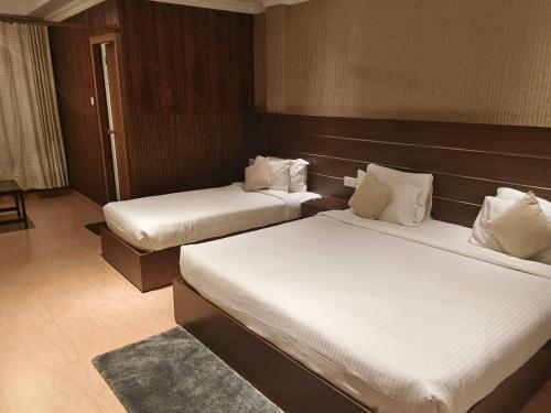 a hotel room with two beds in a room at Matha Residency Munnar in Suryanelli