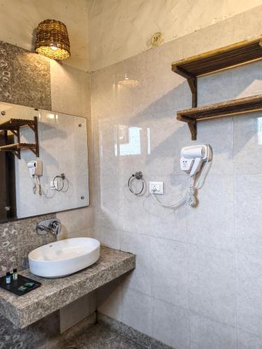 a bathroom with a sink and a mirror at Corbett Soho Resort in Haldwāni