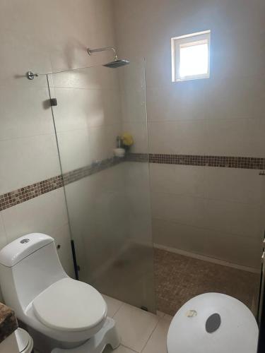 a bathroom with a toilet and a glass shower at Casa Victoria in Colima