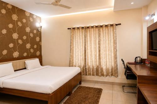 a hotel room with a bed and a television at Hotel Sunshine Inn in Mughal Sarāi