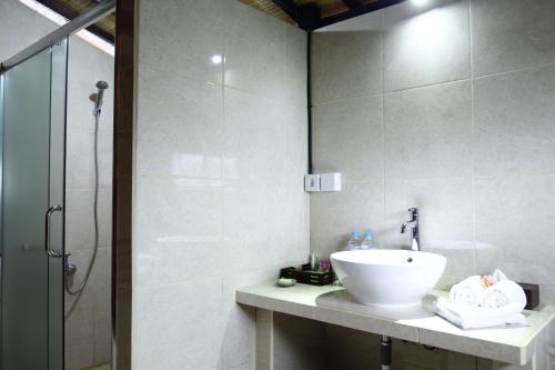 a bathroom with a sink and a shower at Puri Karang Besakih in Menanga