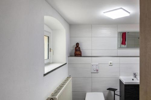 a white bathroom with a toilet and a sink at Andrea Vacation Home in Döbeln