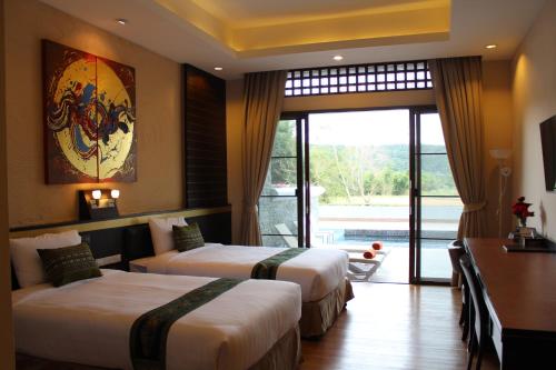 a hotel room with two beds and a window at Phurua Sanctuary Resort and Spa in Phu Rua