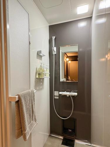 a bathroom with a shower and a mirror at ふくさぶろ in Ushikubi