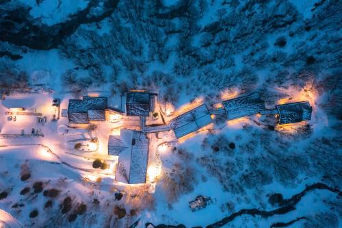 an aerial view of a building in the snow with lights at Hakkoda Hotel in Aomori