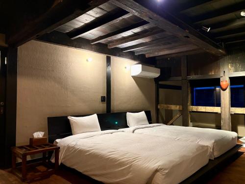 a bedroom with a large white bed in a room at ふくさぶろ in Ushikubi