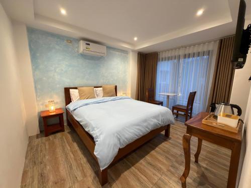 a bedroom with a bed and a table and a desk at Frania Sea Suites in san juan la union