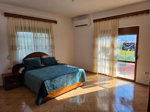 a bedroom with a bed and a large window at Villa Greku in Dushnik