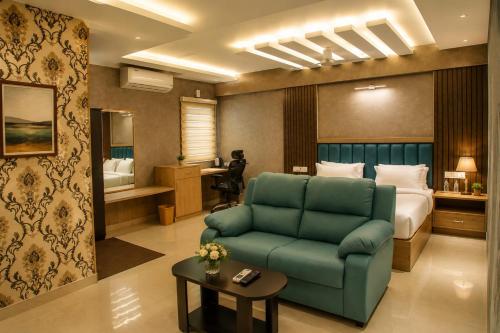 a hotel room with a green couch and a bed at The Park Lane Hotel in Krishnagiri