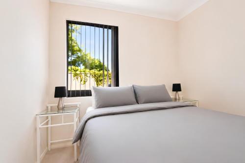 a white bedroom with a bed and a window at Midland Haven - Midland WA in Midland Junction