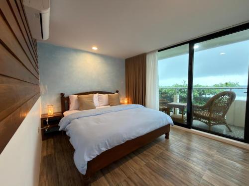 a bedroom with a large bed and a large window at Frania Sea Suites in san juan la union