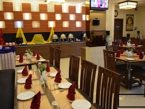 a restaurant with a long table with red napkins on it at Hotel Sai Jashan Shirdi - Where blessings & comfort meet in Shirdi