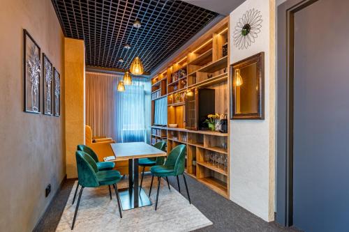 a dining room with a table and green chairs at CENTRAL PARK FLORA in Olomouc